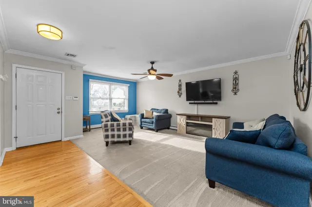 a living room with furniture a flat screen tv and a window
