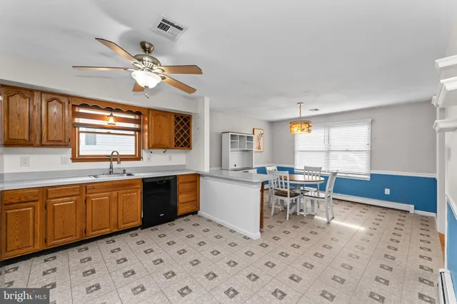 a kitchen with a dining table chairs cabinets and stainless steel appliances