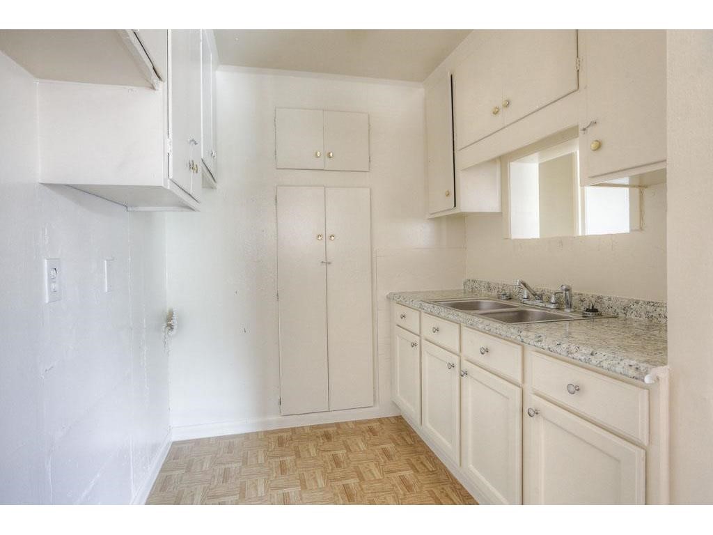 1755 Colquitt Street, Unit 7 Houston, TX 77098 - Photo 16 of 20 a bathroom with granite countertop white cabinets and a sink