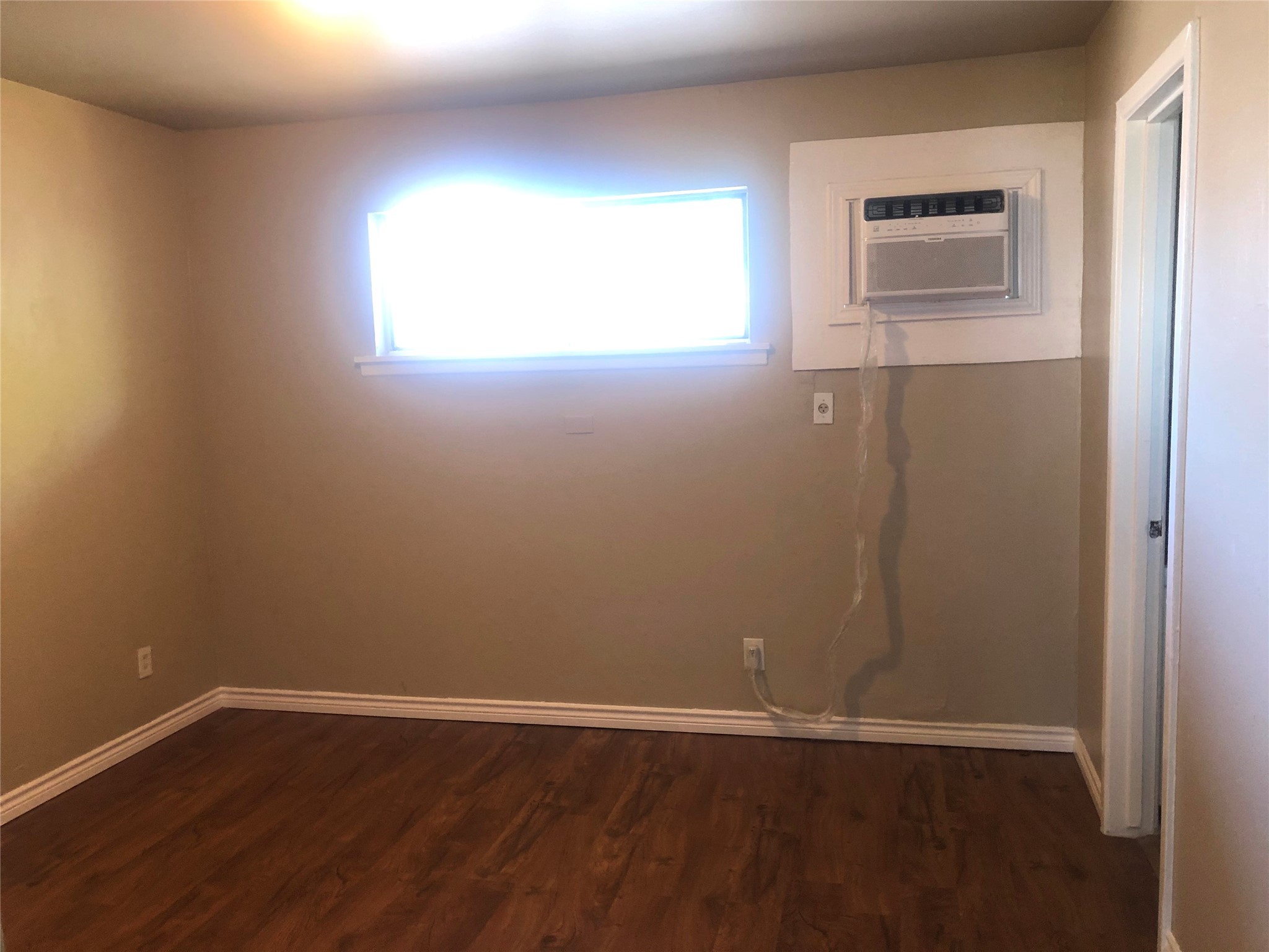 1755 Colquitt Street, Unit 7 Houston, TX 77098 - Photo 5 of 20 an empty room with wooden floor and windows