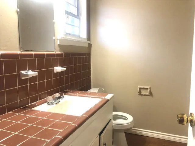 a bathroom with a sink a toilet and a mirror