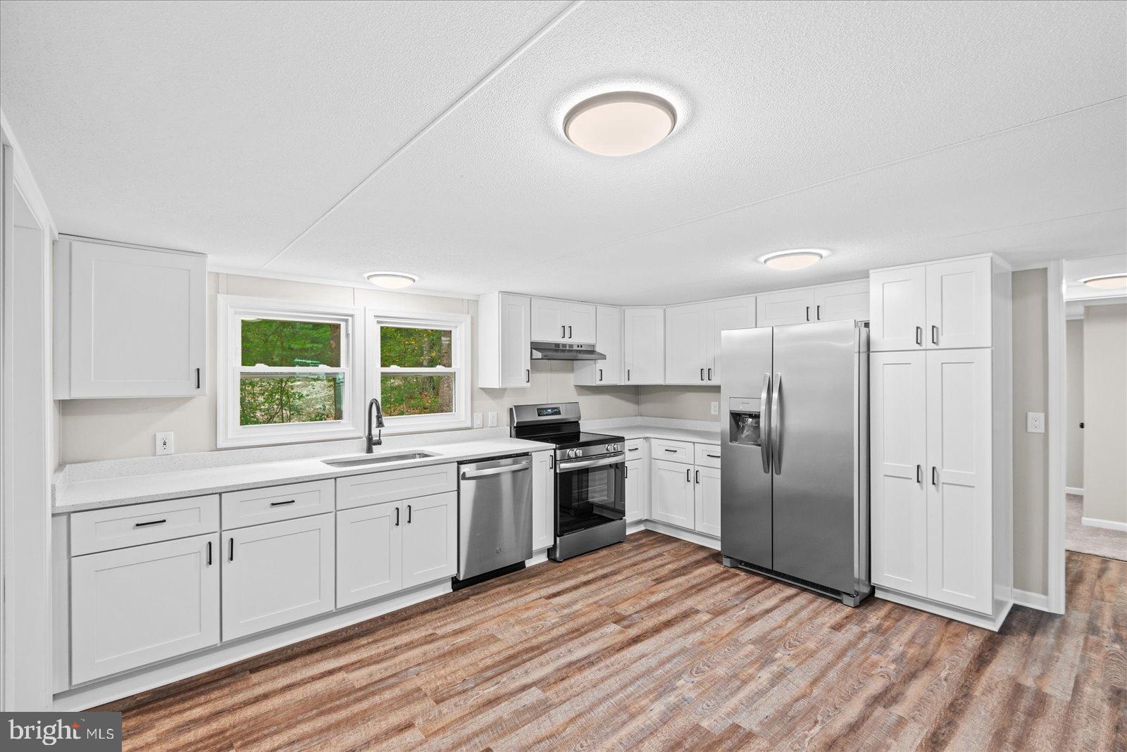 20105 Sparta Road Milford, VA 22514 - Photo 14 of 48 a kitchen with stainless steel appliances a refrigerator sink and cabinets