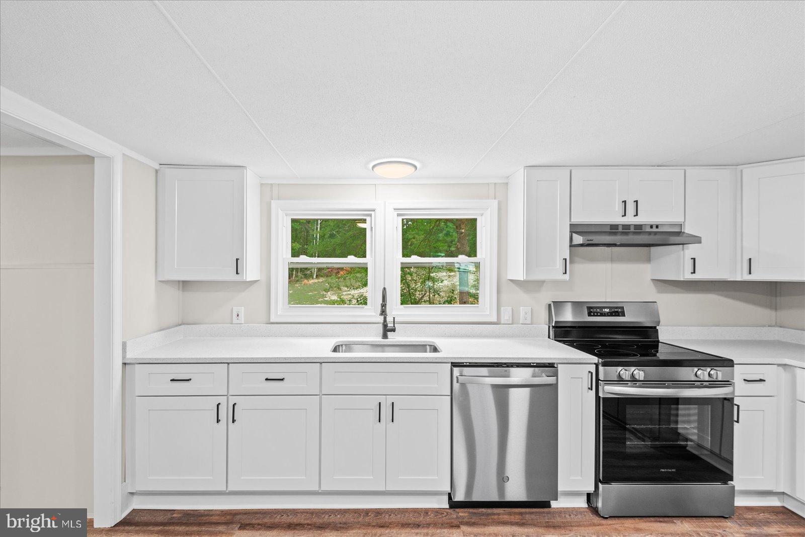20105 Sparta Road Milford, VA 22514 - Photo 15 of 48 a kitchen with stainless steel appliances granite countertop a stove and white cabinets