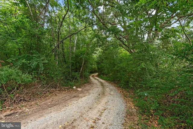 an aerial view of a house with swimming pool and wooden fence