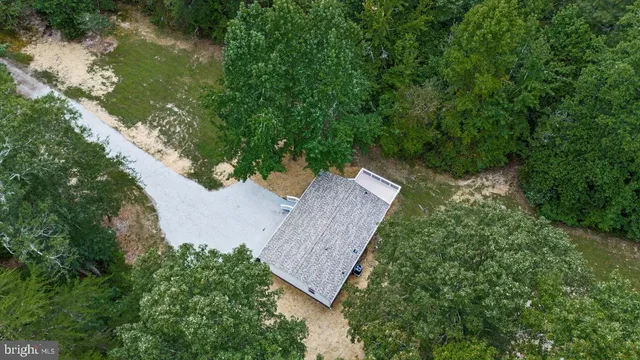 an aerial view of a house with a yard and wooden fence