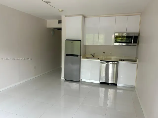 a kitchen with stainless steel appliances a refrigerator a stove a microwave and cabinets