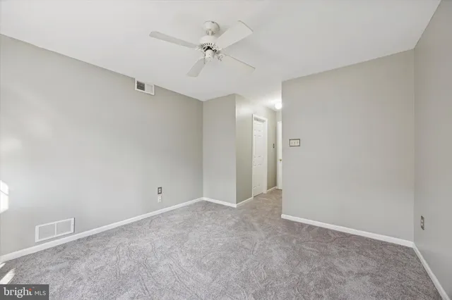 an empty room with a ceiling fan and a window