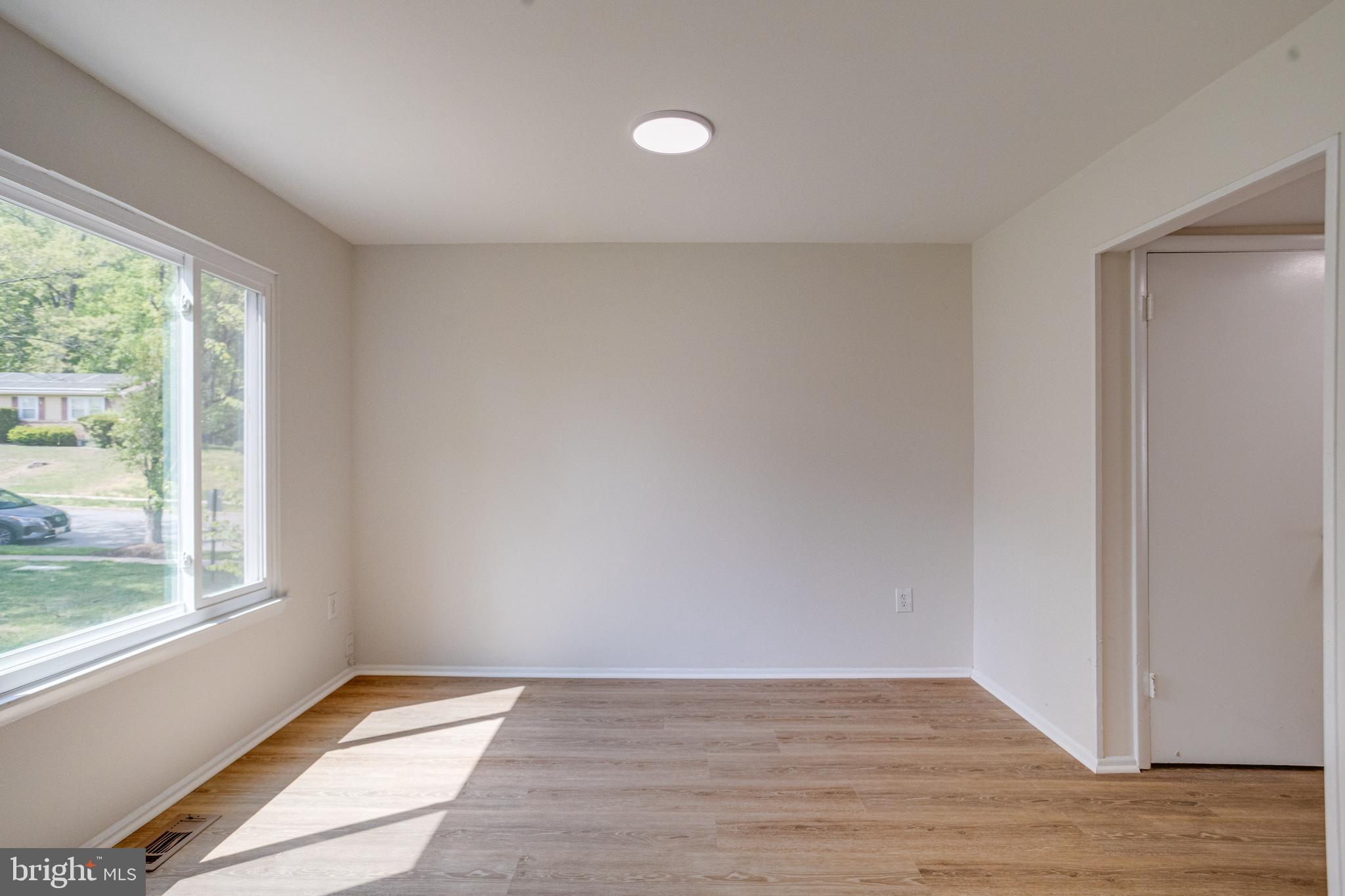 15925 Dorset Road, Unit 199 Laurel, MD 20707 - Photo 13 of 50 a view of an empty room with wooden floor and a window