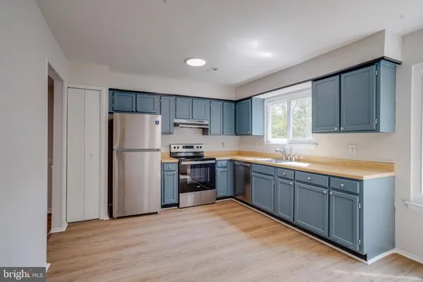 a kitchen with stainless steel appliances granite countertop a refrigerator sink and wooden cabinets