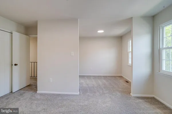 an empty room with windows and closet