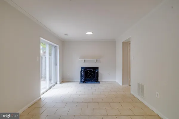 an empty room with fireplace and windows