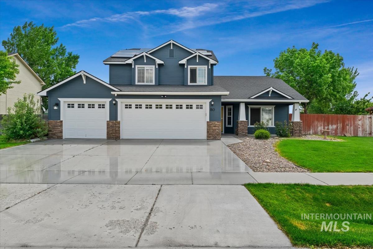 80 Cobblestone Court Middleton, ID 83644 - Photo 1 of 48 Two-story residence featuring a dark blue exterior with white trim, a three-car garage, and stone accents