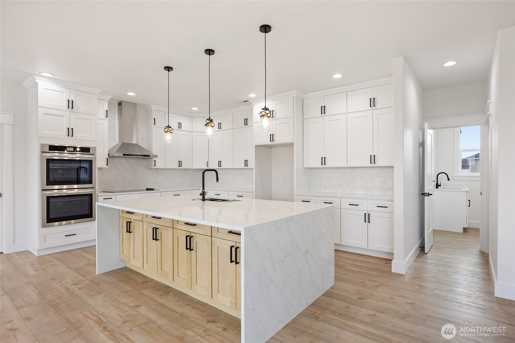 2394 Hunters Street Ephrata, WA 98823 - Photo 11 of 40 a large kitchen with stainless steel appliances kitchen island granite countertop a stove a sink a refrigerator and white cabinets with wooden floor