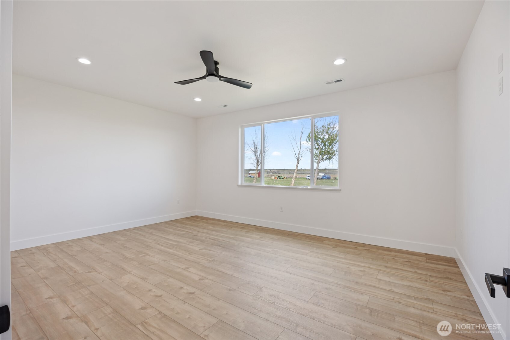 2394 Hunters Street Ephrata, WA 98823 - Photo 18 of 40 an empty room with wooden floor ceiling fan and windows