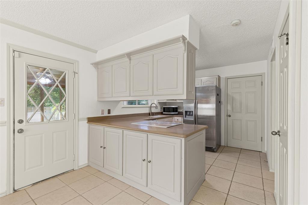 1013 Mockingbird Drive Grapevine, TX 76051 - Photo 11 of 26 a kitchen with cabinets and window