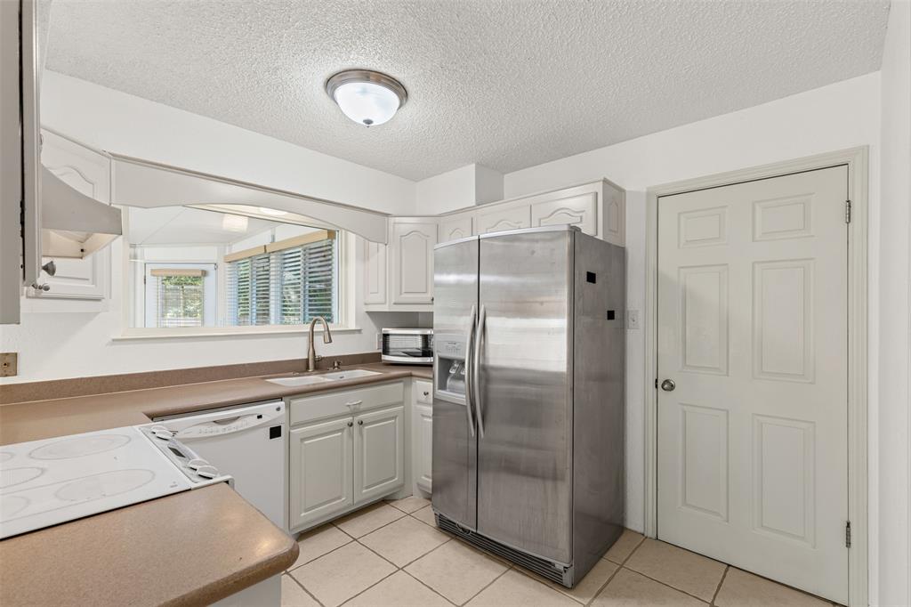1013 Mockingbird Drive Grapevine, TX 76051 - Photo 12 of 26 a kitchen with stainless steel appliances granite countertop a refrigerator and a sink
