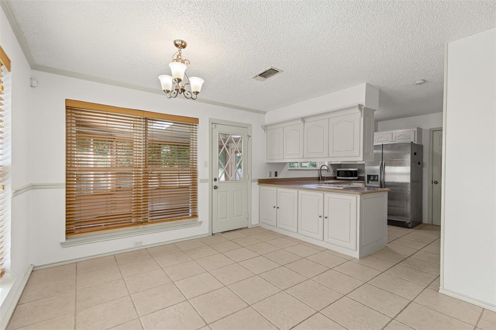 1013 Mockingbird Drive Grapevine, TX 76051 - Photo 13 of 26 a kitchen with a refrigerator a stove and a sink