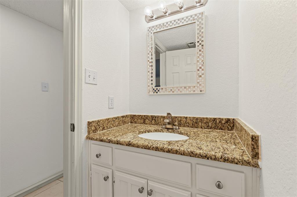 1013 Mockingbird Drive Grapevine, TX 76051 - Photo 14 of 26 a bathroom with a granite countertop sink and a mirror