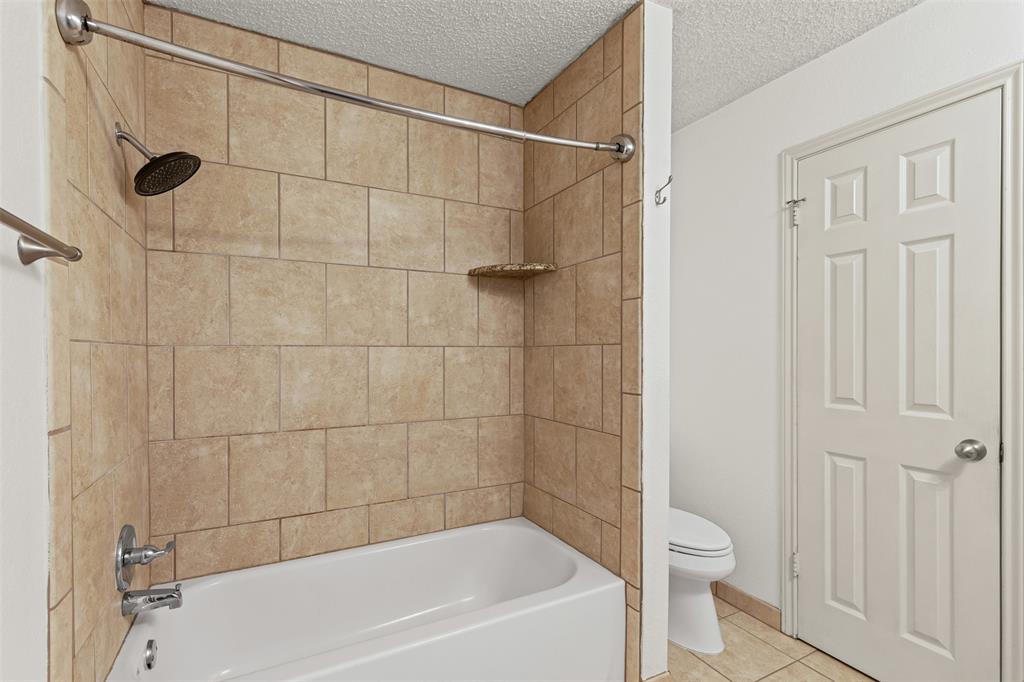 1013 Mockingbird Drive Grapevine, TX 76051 - Photo 18 of 26 a bathroom with a bathtub and a shower