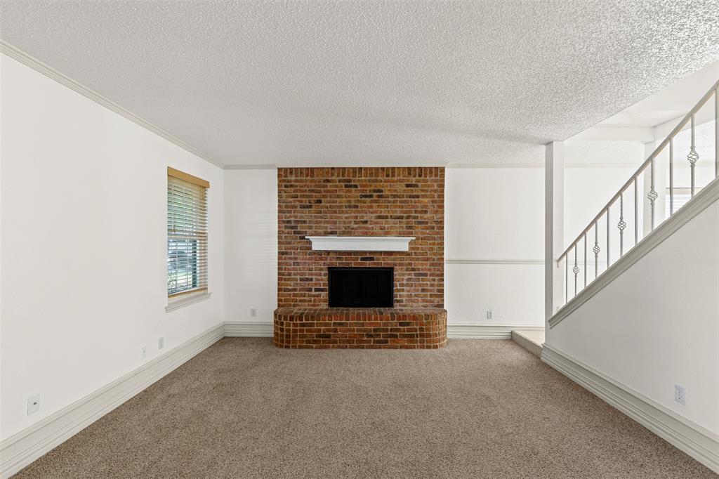 1013 Mockingbird Drive Grapevine, TX 76051 - Photo 6 of 26 a view of an empty room with wooden floor fireplace and a window