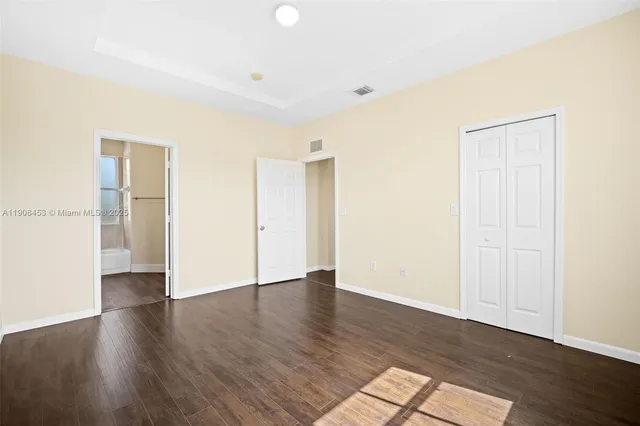 a view of an empty room with wooden floor