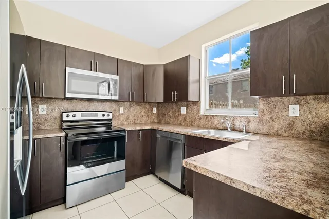 a kitchen with stainless steel appliances granite countertop a sink stove and microwave