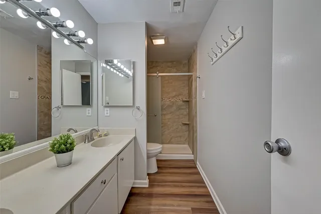 a spacious bathroom with a granite countertop sink a mirror and a shower