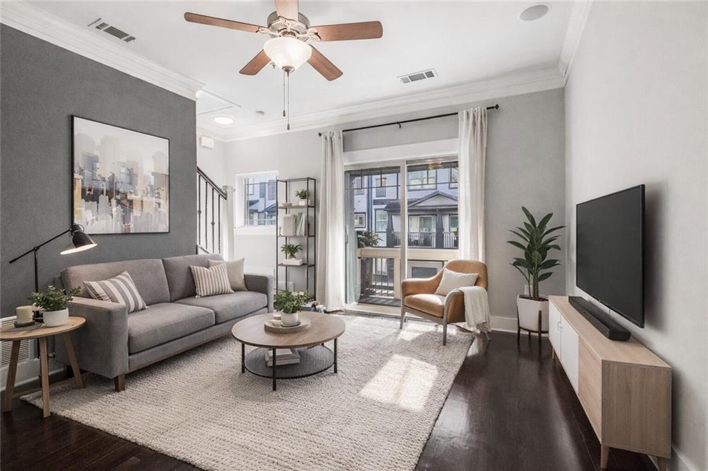 a living room with furniture a flat screen tv and a potted plant