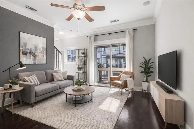 a living room with furniture a flat screen tv and a potted plant