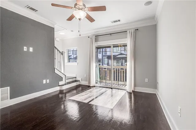 a view of a livingroom with wooden floor and a ceiling fan