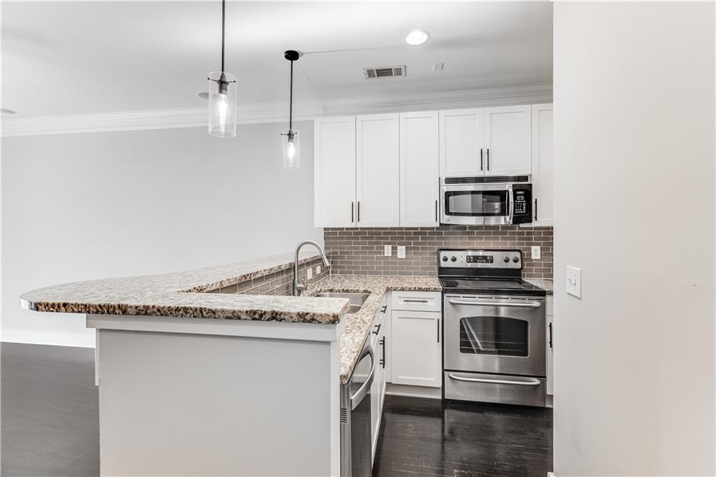 216 Semel Circle Northwest, Unit 355 Atlanta, GA 30309 - Photo 9 of 48 a kitchen with stainless steel appliances granite countertop a sink stove and microwave