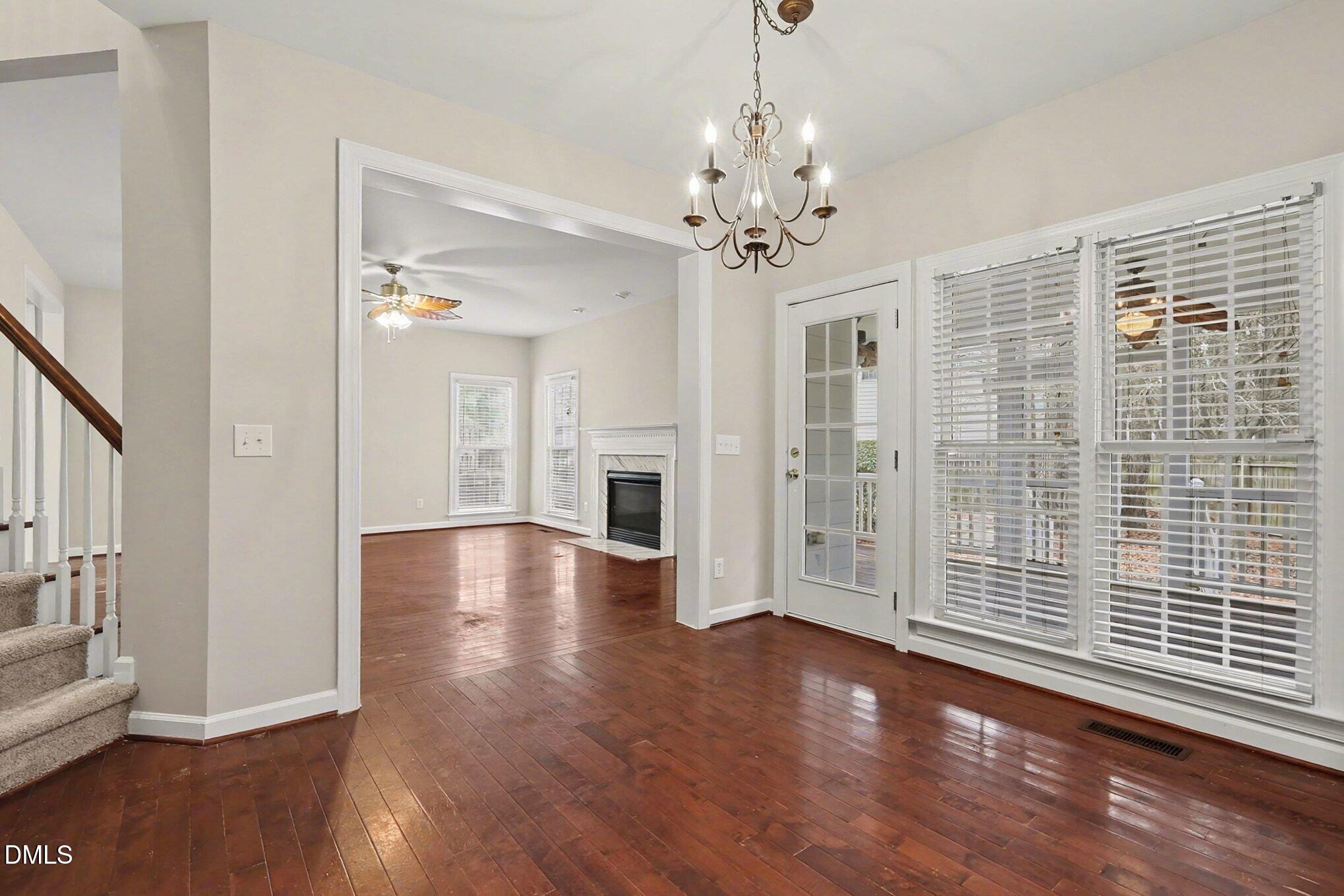 6101 Tiffield Way Wake Forest, NC 27587 - Photo 12 of 40 a view of a livingroom with wooden floor a ceiling fan and windows