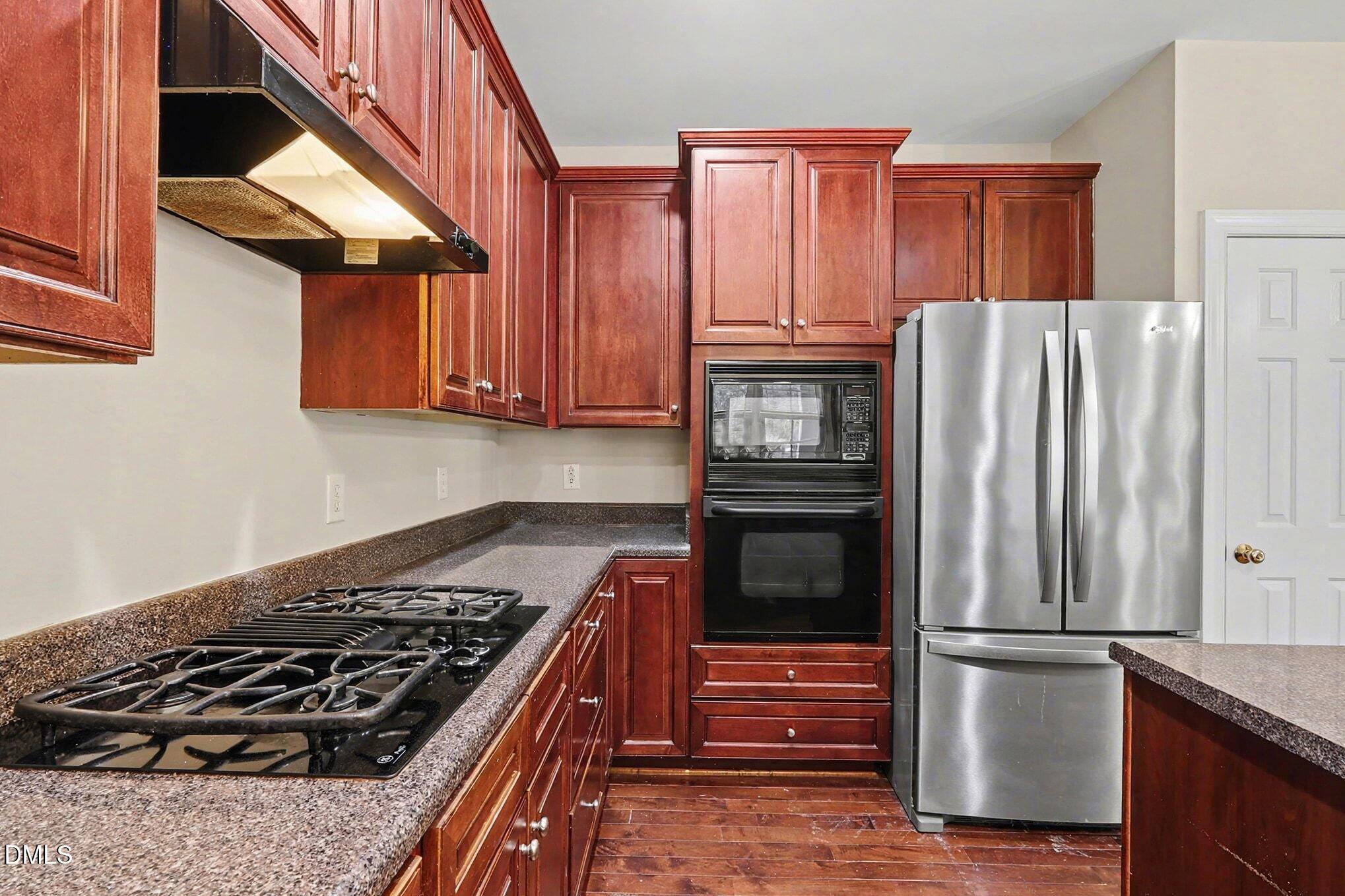 6101 Tiffield Way Wake Forest, NC 27587 - Photo 14 of 40 a kitchen with wooden cabinets and a stove top oven