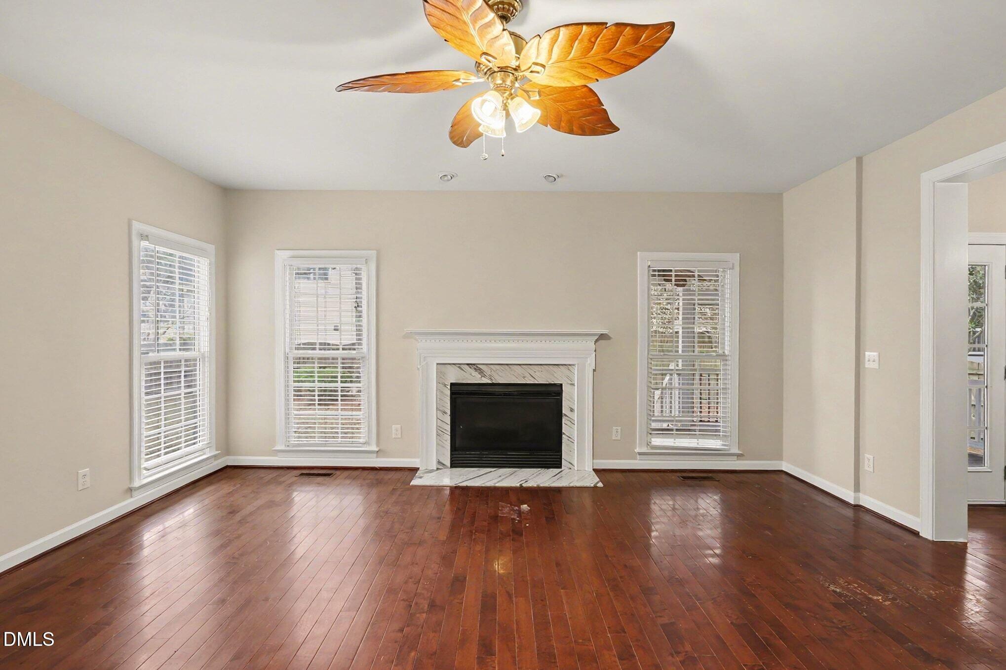 6101 Tiffield Way Wake Forest, NC 27587 - Photo 10 of 40 an empty room with windows fireplace and wooden floor