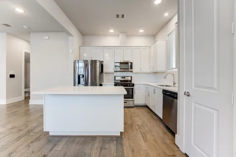 a kitchen with cabinets and wooden floor