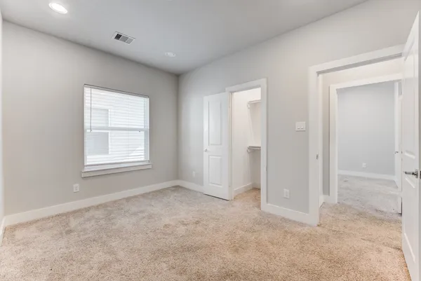 an empty room with windows and closet