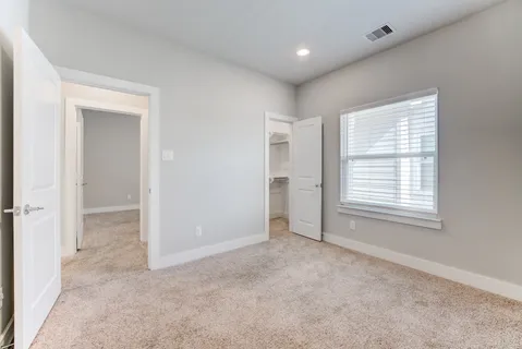 an empty room with windows and closet