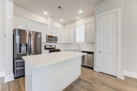 a kitchen with stainless steel appliances a refrigerator stove microwave and sink
