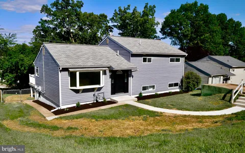 a view of a house with backyard and trees