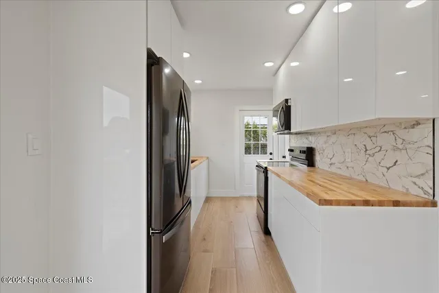a kitchen with stainless steel appliances granite countertop a refrigerator and a sink