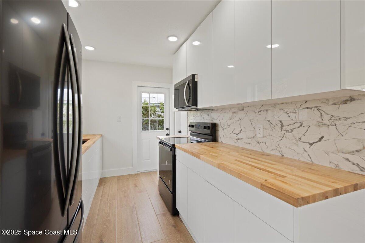 301 West Rutgers Street Melbourne, FL 32901 - Photo 25 of 36 a kitchen with stainless steel appliances granite countertop a refrigerator a sink and a stove