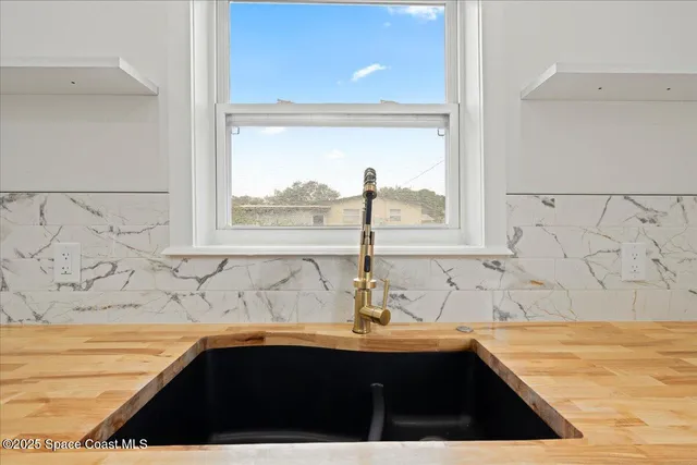 a bathroom with a granite countertop sink a window and a bathtub
