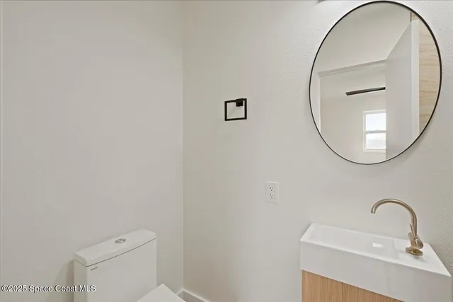 a bathroom with a sink a mirror and a toilet