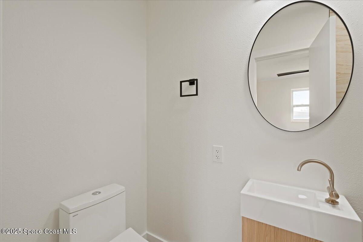 301 West Rutgers Street Melbourne, FL 32901 - Photo 10 of 36 a bathroom with a sink a mirror and a toilet