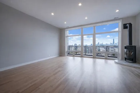 an empty room with wooden floor and floor to ceiling window