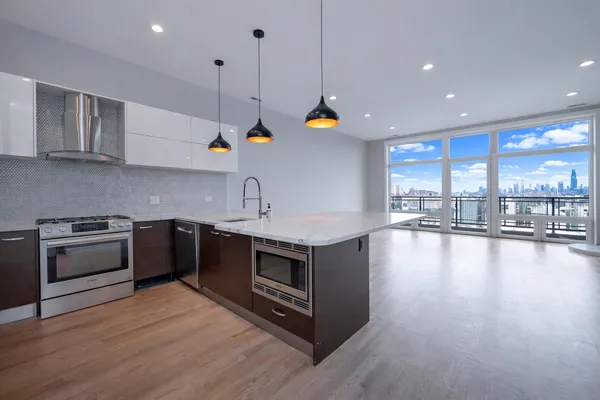 a kitchen with stainless steel appliances granite countertop a stove a sink a refrigerator and a wooden cabinets