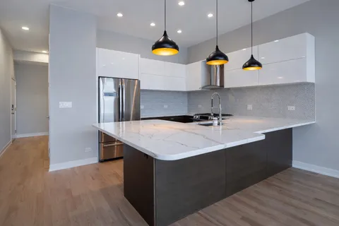 a kitchen with stainless steel appliances granite countertop a sink a counter top space cabinets and wooden floor