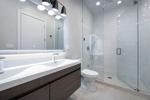 a bathroom with a sink a toilet and shower