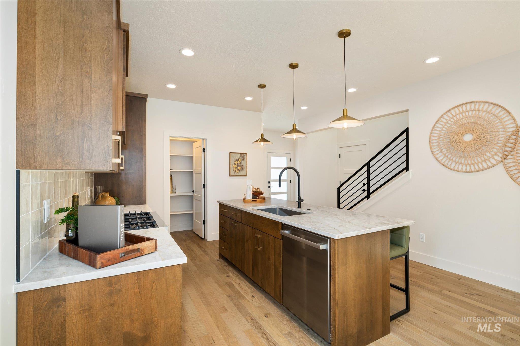 5612 West Grover Street Boise, ID 83705 - Photo 16 of 50 Kitchen with dishwasher, an island with sink, light stone counters, light wood-style flooring, and recessed lighting