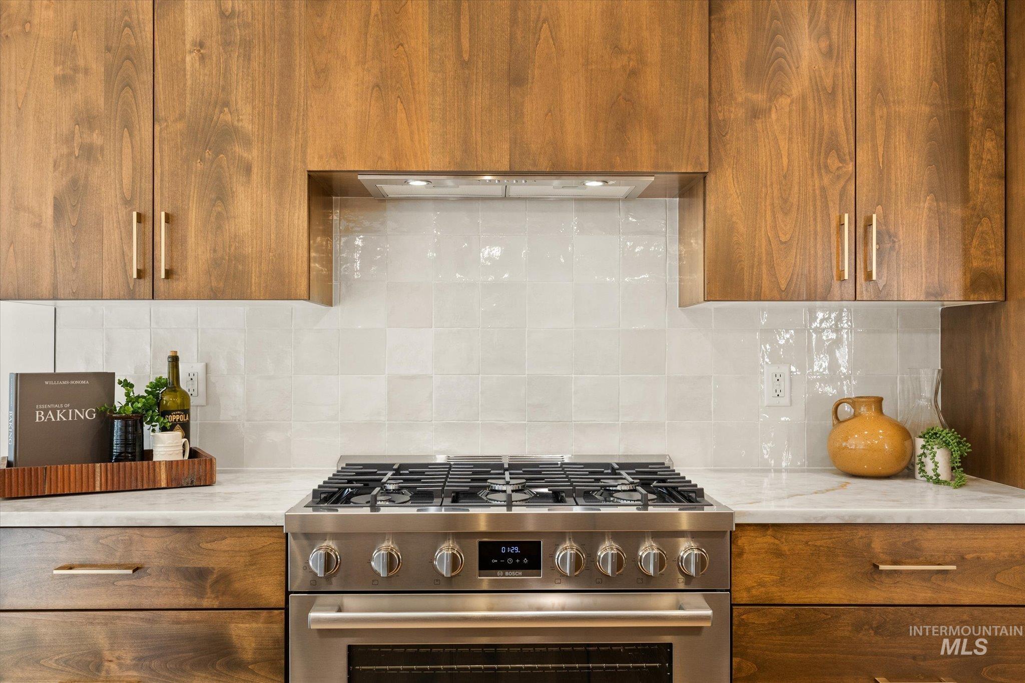 5612 West Grover Street Boise, ID 83705 - Photo 17 of 50 Kitchen with high end range, brown cabinets, and backsplash